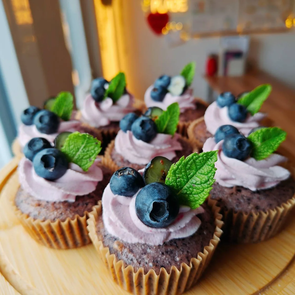 Schokoladen-Cupcakes mit violetter Creme, Blaubeeren und frischer Minze